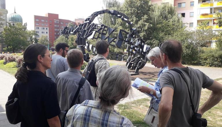 Transparente Weltkugel - Führung „Kunst im Stadtraum – DDR Kunst im Kontext“, Eine Personengruppe während einer Führung vor dem Kunstwerk "Transparente Weltkugel"
