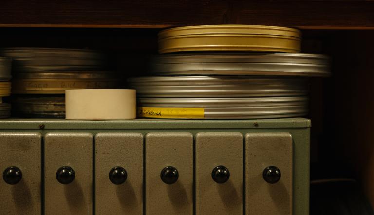 Gestapelte Filmrollen in Metallbüchsen auf einem Regal, darunter Schubladen mit schwarzen Knöpfen., Foto: Julia Nimke, Lizenz: PMSG