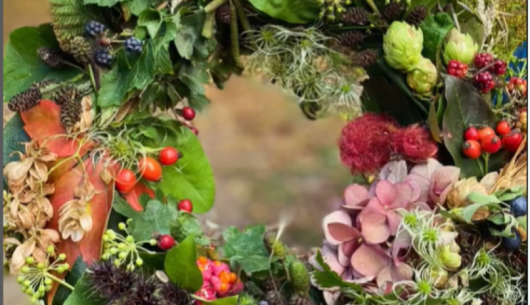 Herbstkranz aus grünen Blättern, roten Beeren, Zapfen, Hopfen und Hortensien, in Händen gehalten., Foto: Nicole Riekeles, Lizenz: Nicole Riekeles