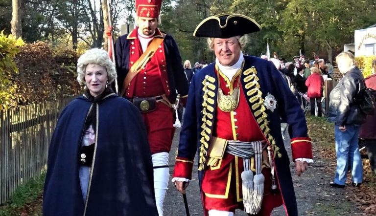 Mike Sprenger als König Friedrich Wilhelm I. und Manuela Sprenger als Königin Sophie Dorothea im Hintergrund ein „Langer Kerl“, Foto: Förderverein Jagdschloss Stern-Parforceheide e.V., Lizenz: Förderverein Jagdschloss Stern-Parforceheide e.V.