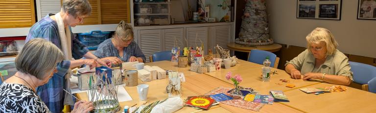 Vier Frauen basteln an einem Tisch.
