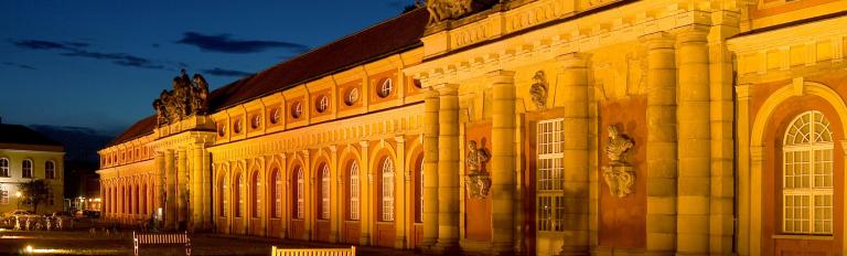 Das Filmmuseum Potsdam wird in der Abenddämmerung beleuchtet.