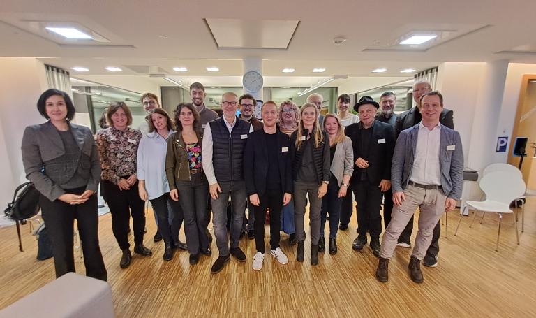 Gruppenfoto von etwa 20 Personen in einem hellen Raum. Auf der linken Seite steht die Oberbürgermeisterin Noosha Aubel gemeinsam mit den Mitgliedern des Digitalisierungsrates.