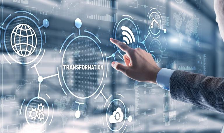 Das Bild zeigt einen Touchscreen mit Symbolen für W-Lan, Cloud und das Internet sowie den Schriftzug Transformation. Eine Hand berührt den Touchscreen.
